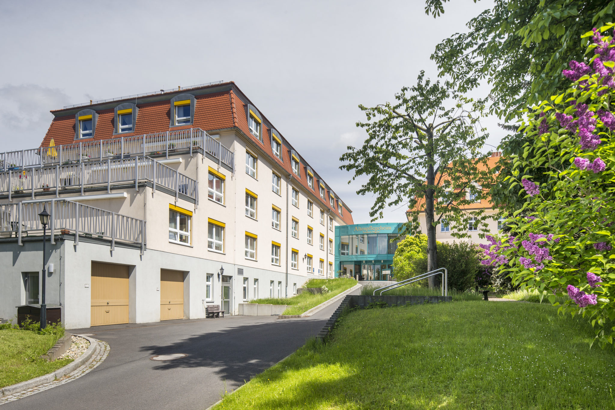 Außenansicht des Gebäudes mit Park und Bäumen