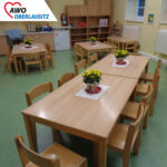 Gruppenraum, wo die Tische mit Blumen gedeckt sind.
