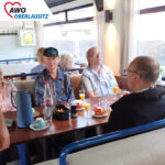 AWO Klienten sitzen mit Getränken am Tisch.