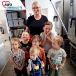 Küchenfrau und sechs Kinder machen ein Bild zusammen