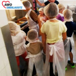 viele Kinder stehen um den Herd herum