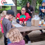 Viele Kinder am Stand beim Kinderfest fertigen ihre Buttons selber.