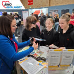 Schülerinnen beim Beratungsgespräch zu Ausbildungsmöglichkeiten in der Region am Messestand der AWO Oberlausitz