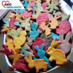 Auf einem Edelstahltablett liegen kunterbunte Osterplätzchen - blaue Hasen, gelbe Küken, pinke Eier und vieles mehr.